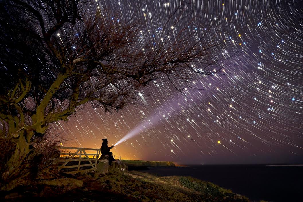 starry night sky with man and torch